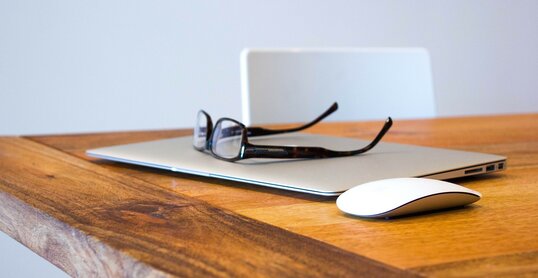 Laptop mit Brille auf dem Tisch