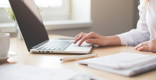 Notebook mit Frauenhand und Block