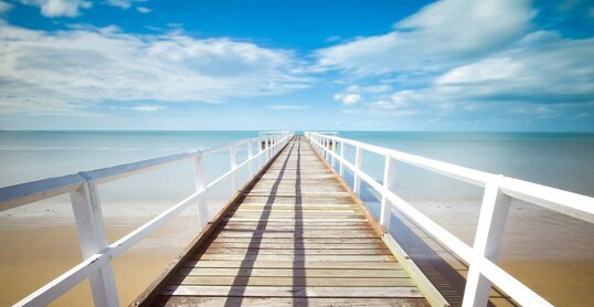 Holzsteg ins Meer führend